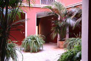 a pink building with palm trees in a courtyard at Apartamento Judería Lirio alto in Seville