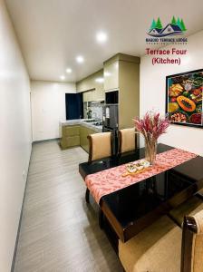 a living room with a table and a kitchen at Baguio Terrace Lodge in Baguio
