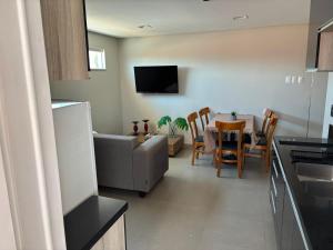 a kitchen and living room with a couch and a table at Suites Coliseu 40-A in Petrolina
