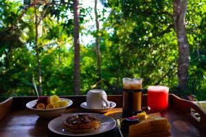 a table with plates of breakfast food and a drink at Exotic private glamping in Nusa Penida