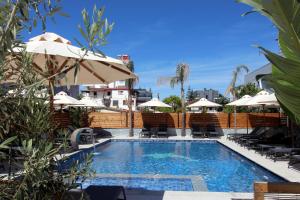 a large swimming pool with chairs and umbrellas at Hotel Villa Kapo Pool & Bar in Ksamil