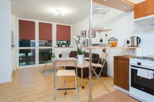 a kitchen and living room with a table and chairs at ShortStayPoland Graniczna (B6) in Warsaw