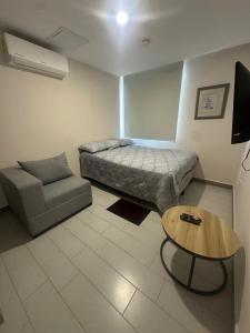 a bedroom with a bed and a couch and a table at Angies Loft in Tegucigalpa