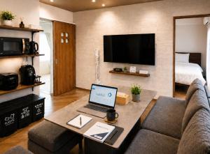 a living room with a laptop on a table at WinGoodDays in Kumamoto