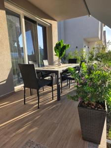 a patio with a table and chairs and some plants at Villa Gala - First Floor Apartment in Draç