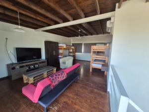 a living room with a couch and a flat screen tv at Terrazas de la Quinta - Cabañas de Montaña in Mendoza
