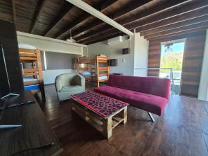 a living room with a purple couch and a table at Terrazas de la Quinta - Cabañas de Montaña in Mendoza +80 photos