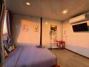a bedroom with a large bed and a television at ชาร์จแบต ภูทับเบิก in Ban Muang Baeng