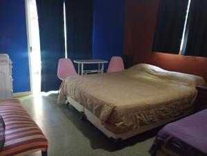 a bedroom with two beds and a table and chairs at Siempre verde3 in Merlo