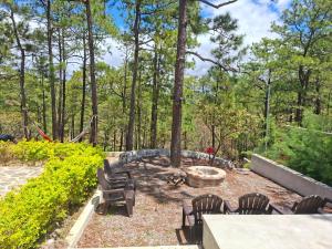 a backyard with chairs and a fire pit and trees at Villa 1991 in San Ignacio +5 photos