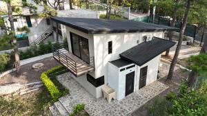 a small white house with a black roof at Villa 1991 in San Ignacio