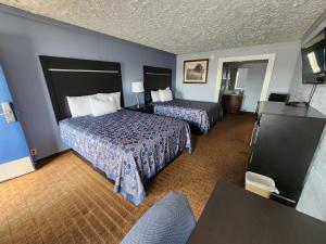 a hotel room with two beds and a television at Rodeway Inn in Carthage