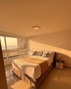 a bedroom with a large bed with a large window at Apartamento en Pampatar in Pampatar