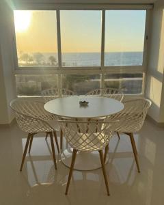 a white table and chairs in front of a window at Apartamento en Pampatar in Pampatar
