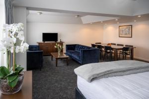 a hotel room with a bed and a dining room at Bay Plaza Hotel in Wellington
