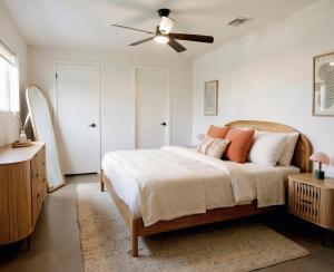 a bedroom with a bed and a ceiling fan at Sonoran Peach - Light-Filled 5BR near TMC in Tucson
