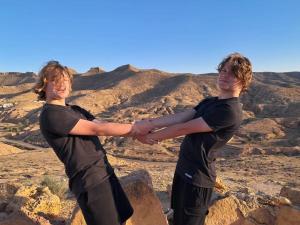 two young men holding hands on top of a mountain at Dar Sana in Qaşr al Ḩallūf