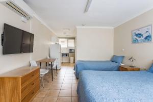 a hotel room with two beds and a television at Emu Point Motel in Albany