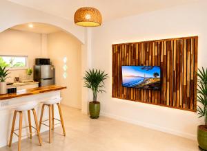 a kitchen with a bar with a television on a wall at Oh'lala Pool Cottages in Ban Tai