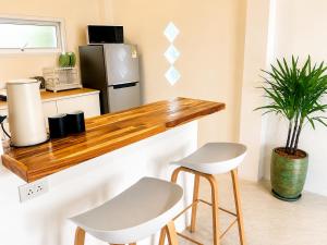 a kitchen with a wooden counter and two stools at Oh'lala Pool Cottages in Ban Tai