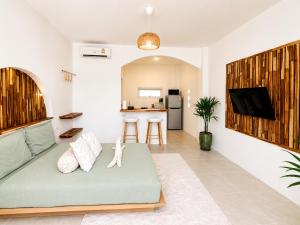 a living room with a couch and a kitchen at Oh'lala Pool Cottages in Ban Tai