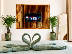 a swan sculpture on a bed with two plants at Oh'lala Pool Cottages in Ban Tai