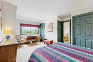 a bedroom with a bed and a desk and a table at GOPI Notch in Franconia