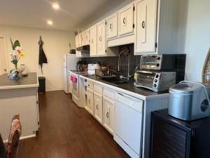 a kitchen with white cabinets and white appliances at DREAM LAND Lake Front CHALET, HOT TUB in Huntingdon