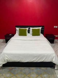 a bedroom with a large bed with a red wall at Light house hotel lekki phase 1 in Araromi +7 photos