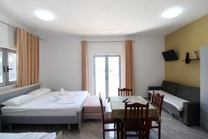 a room with a bed and a table and a couch at Hotel Villa Kapo Pool & Bar in Ksamil +127 photos
