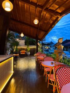 a patio with red and white chairs and tables at The Kayangan Sanur in Sanur