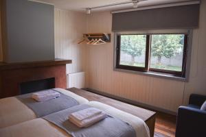 a bedroom with a bed with two towels on it at Casa Curacautin Hostel in Curacautín