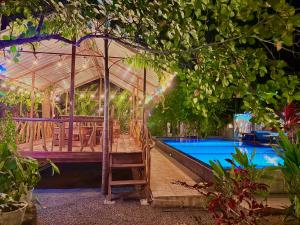 a swimming pool with a tent and a ladder next to a swimming pool at Levona Garden Resort in Habarana