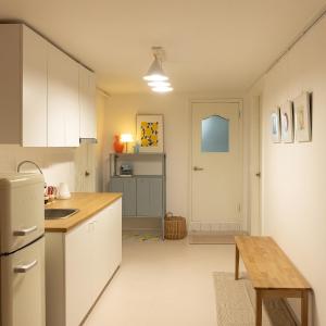 a kitchen with white cabinets and a wooden table at Danchu stay in Seoul