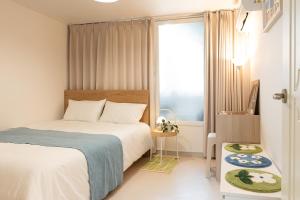 a bedroom with a bed and a window at Danchu stay in Seoul