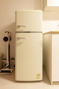 a white refrigerator in the corner of a kitchen at Danchu stay in Seoul +28 photos