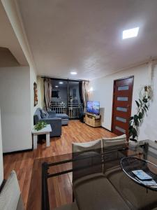 a living room with a couch and a table at Acogedor y amplio departamento central in Temuco