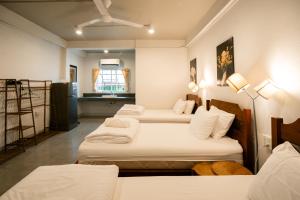 a room with three beds and a ladder in it at Secret Corner Boutique Stay in Chiang Rai