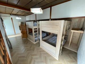 a room with several bunk beds in a room at Old Sunny Garage in Tosashimizu