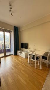 a living room with a table and chairs and a television at Harmonia Apart Hotel in Boreti