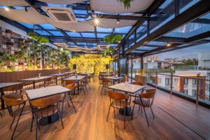 a restaurant with tables and chairs on a balcony at Altuz Apartment Seturan Yogyakarta in Seturan