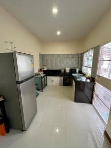 a kitchen with a stainless steel refrigerator at BP Private Home in Ban Nong Sa
