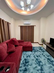 a living room with a red couch and a blue rug at BP Private Home in Ban Nong Sa