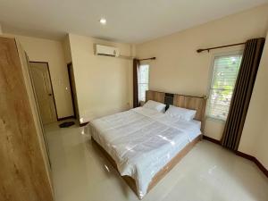 a bedroom with a large bed with white sheets at BP Private Home in Ban Nong Sa