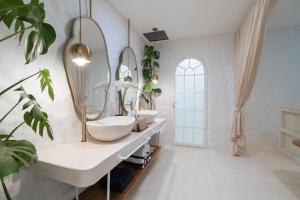 a bathroom with two sinks and a mirror at Makyra by Bohemian Jogja Villas in Kejayan