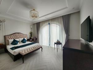 a bedroom with a large bed and a television at WHITE HOTEL in Lạng Sơn +68 photos