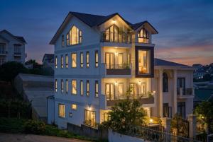 a large white house with its lights on at KP Villa Dalat in Da Lat