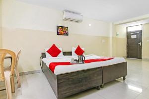 a bedroom with a large bed with red pillows at Hotel O Royal Green in New Delhi +19 photos