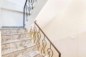 a staircase in a home with white walls and white stair railing at Hotel O Royal Green in New Delhi