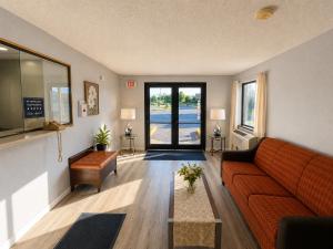 ein Wohnzimmer mit Sofa und Tisch in der Unterkunft Corning Inn in Painted Post